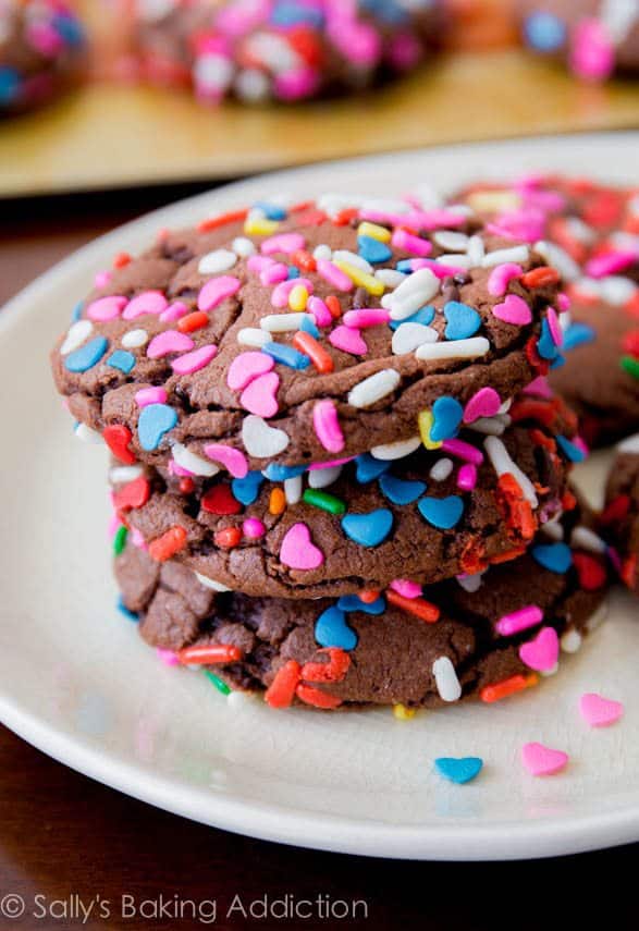 stack of chocolate cake mix cookies with sprinkles on a white plate