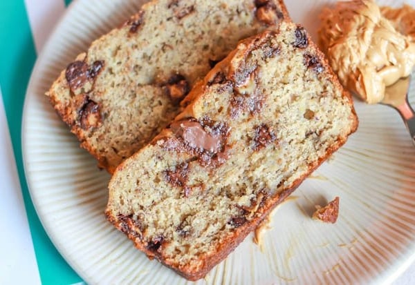 slices of Nutella swirl peanut butter banana bread on a white plate with a spoonful of peanut butter