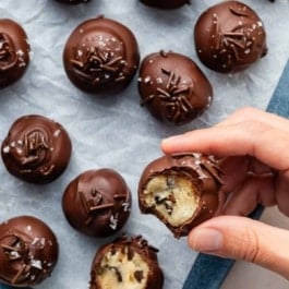hand holding chocolate chip cookie dough truffle.