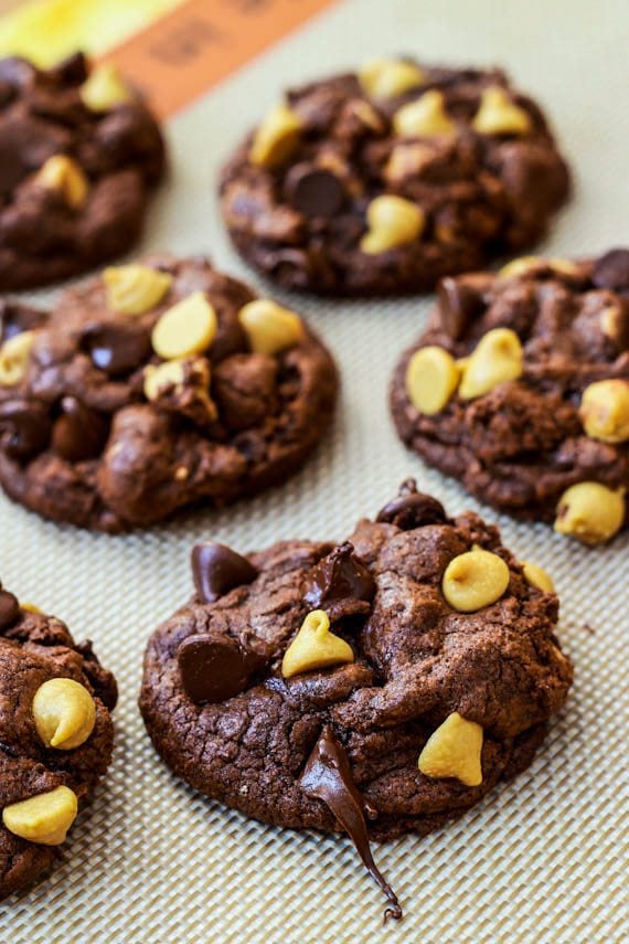 chocolate cookies with chocolate chips and peanut butter chips on a silpat baking mat