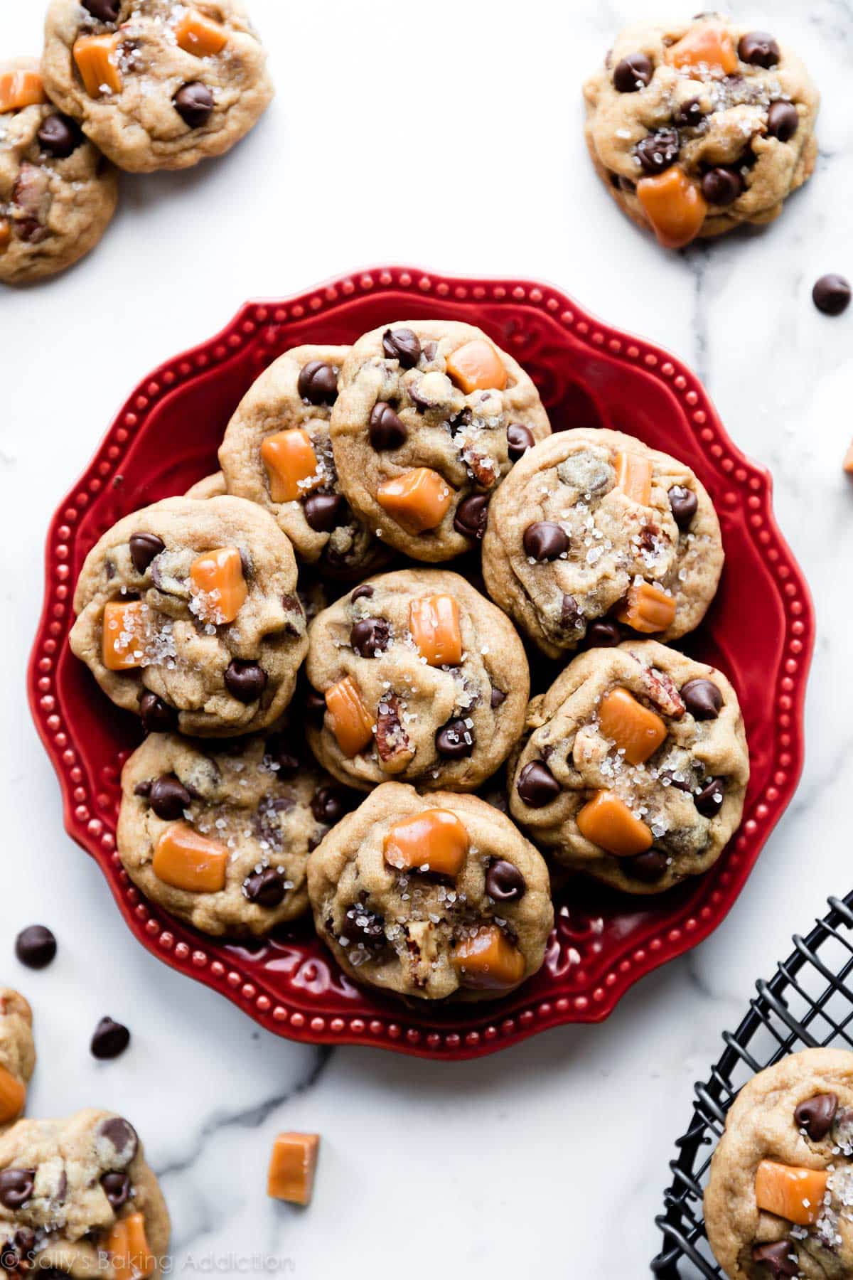 salted caramel pecan chocolate chip cookies on a red plate