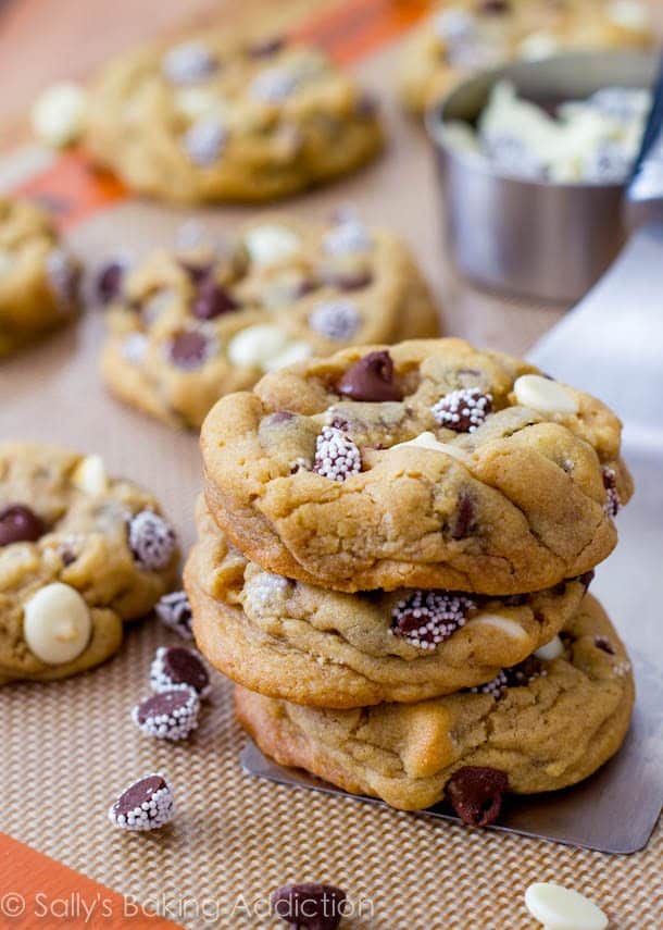 stack of triple chocolate chip cookies on a silpat baking mat with a spatula