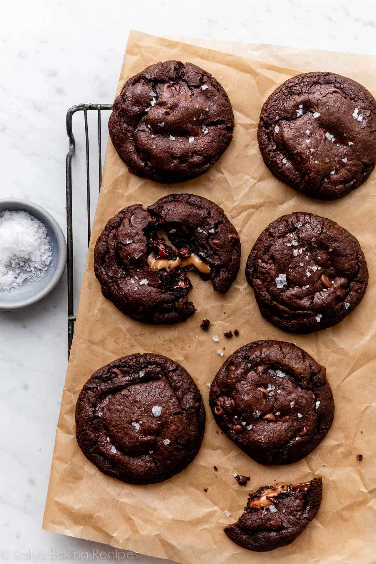 6 salted caramel dark chocolate cookies on brown parchment paper.