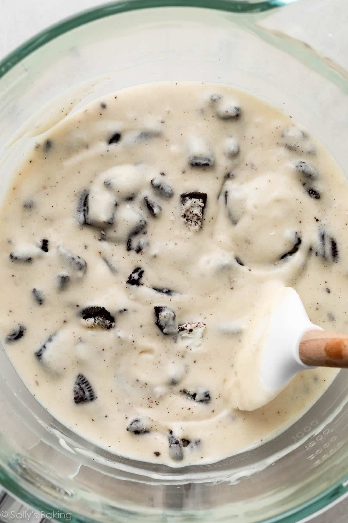 Oreo cupcake batter in bowl with spatula.