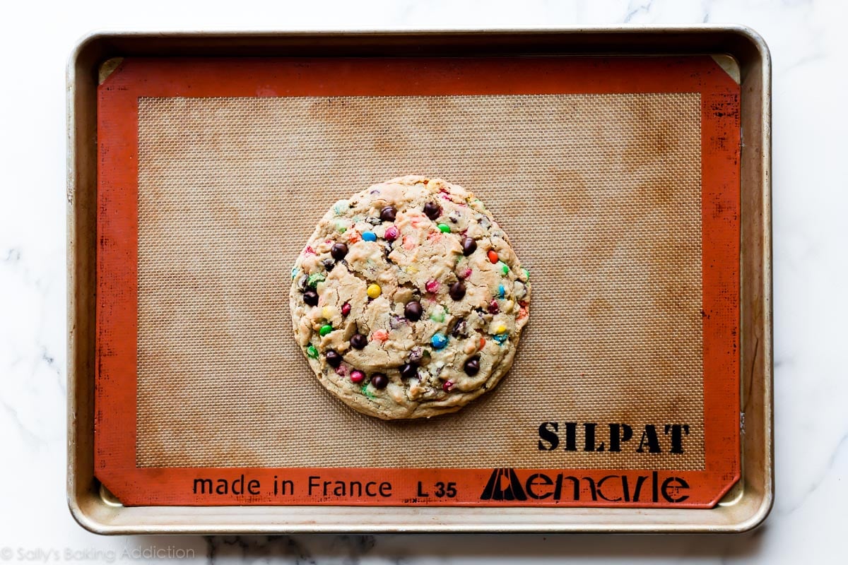 One giant monster cookie on baking sheet after baking