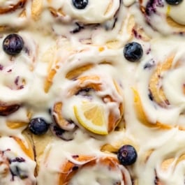 blueberry lemon sweet rolls with cream cheese icing on top.