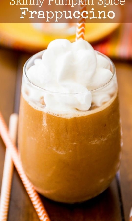 pumpkin frappuccino in a glass with whipped cream and a straw