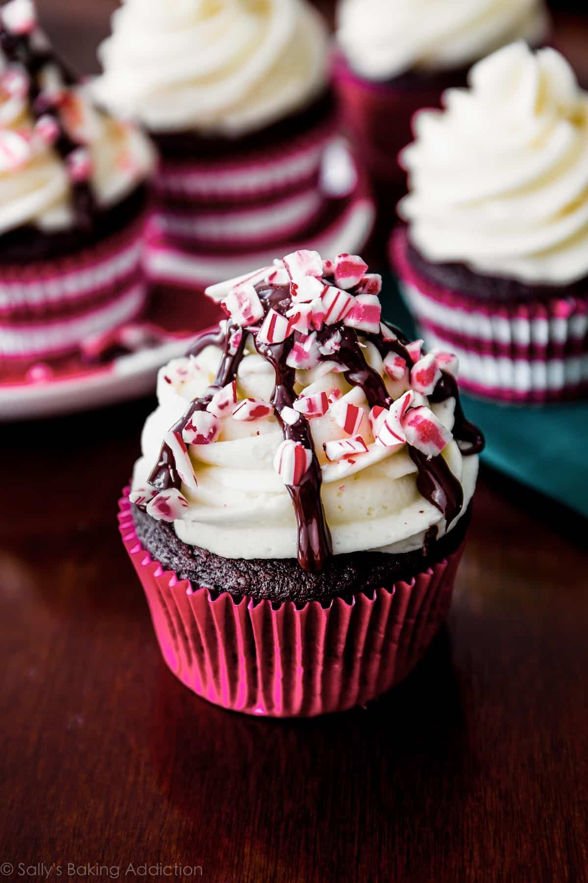peppermint mocha cupcake with a chocolate drizzle and crushed candy canes
