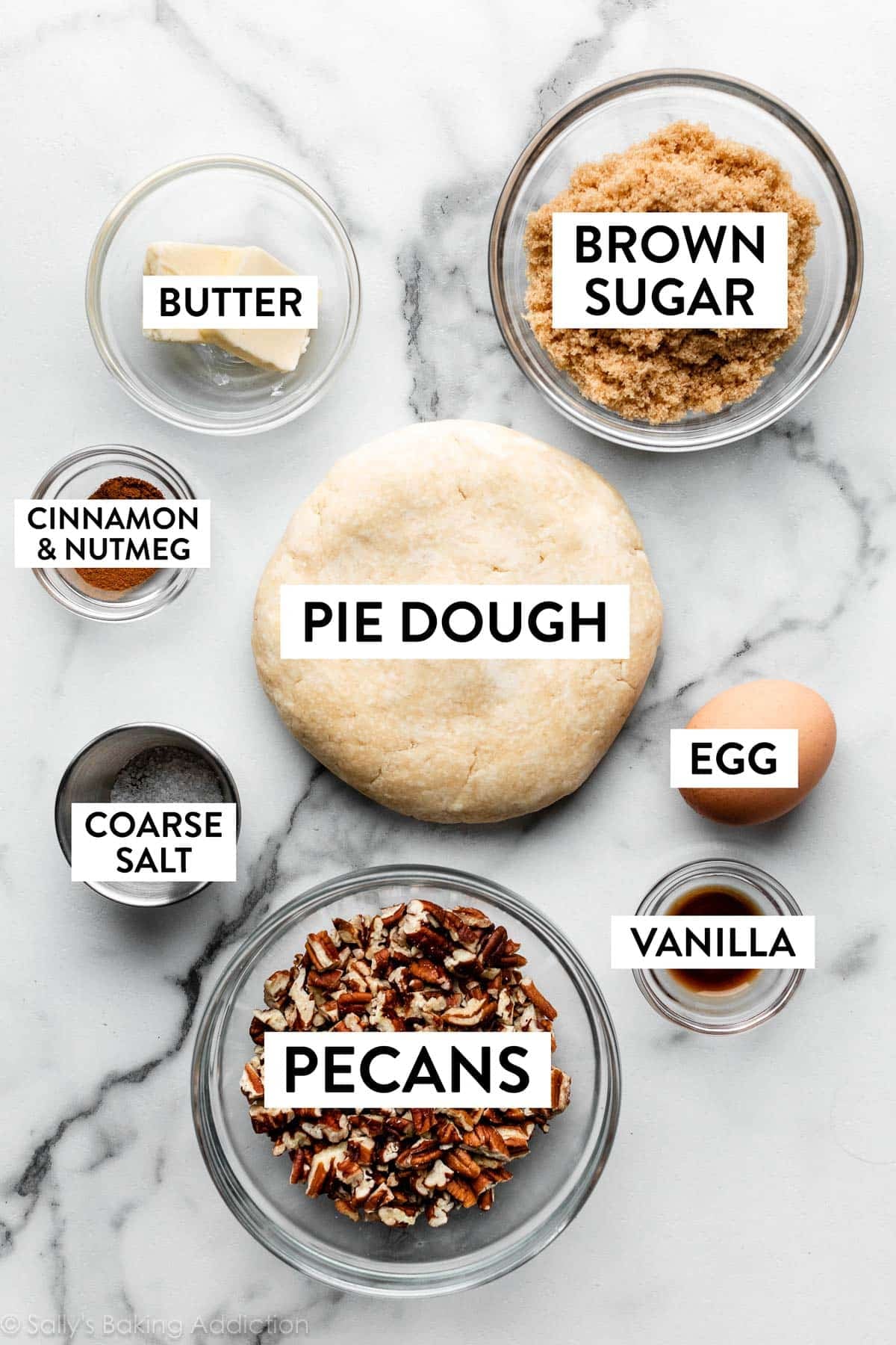 ingredients on counter including brown sugar, pie dough, pecans, egg, vanilla, and butter.