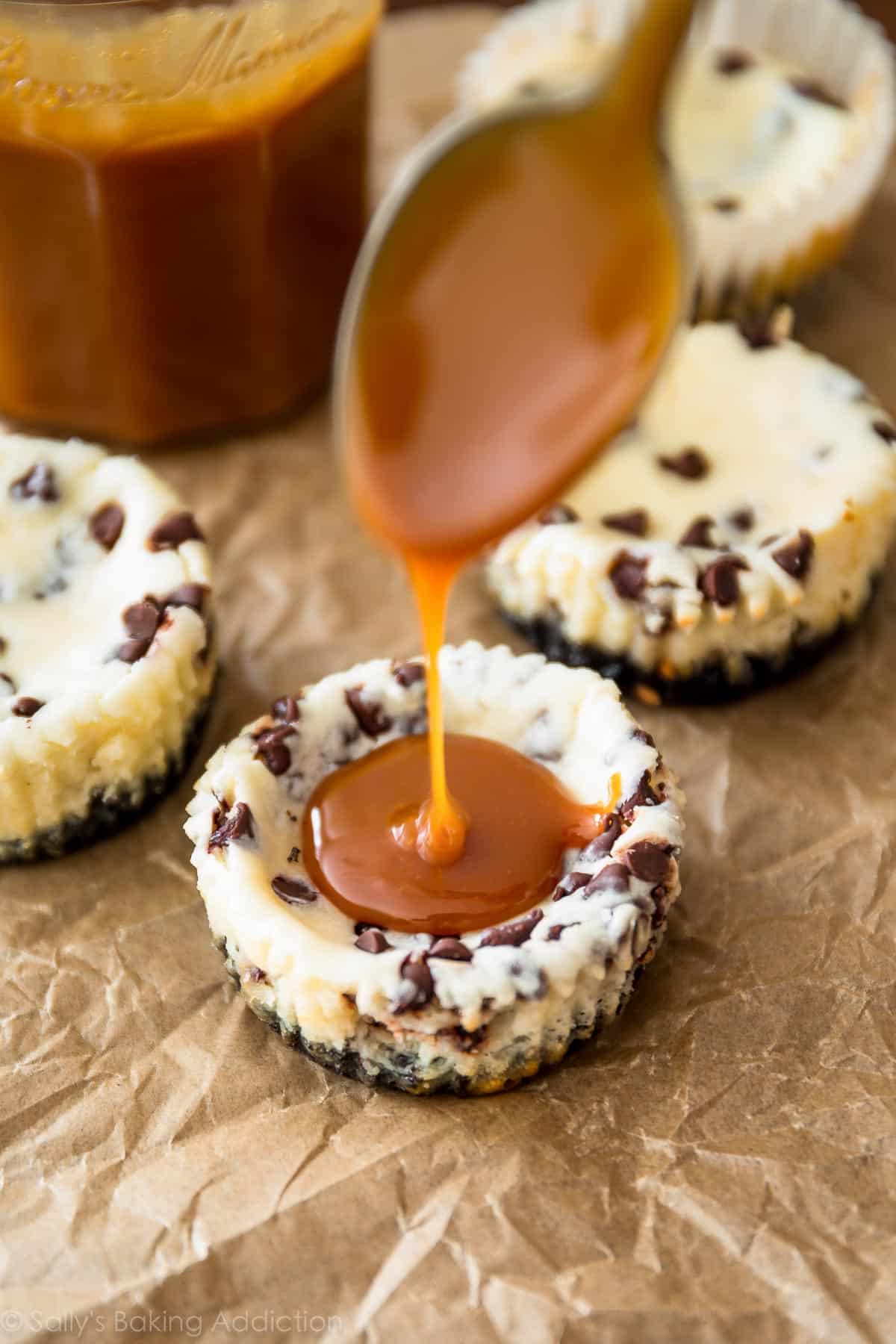 spooning salted caramel onto mini chocolate chip cheesecakes