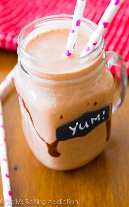 chocolate peanut butter smoothie in a glass mug with straws