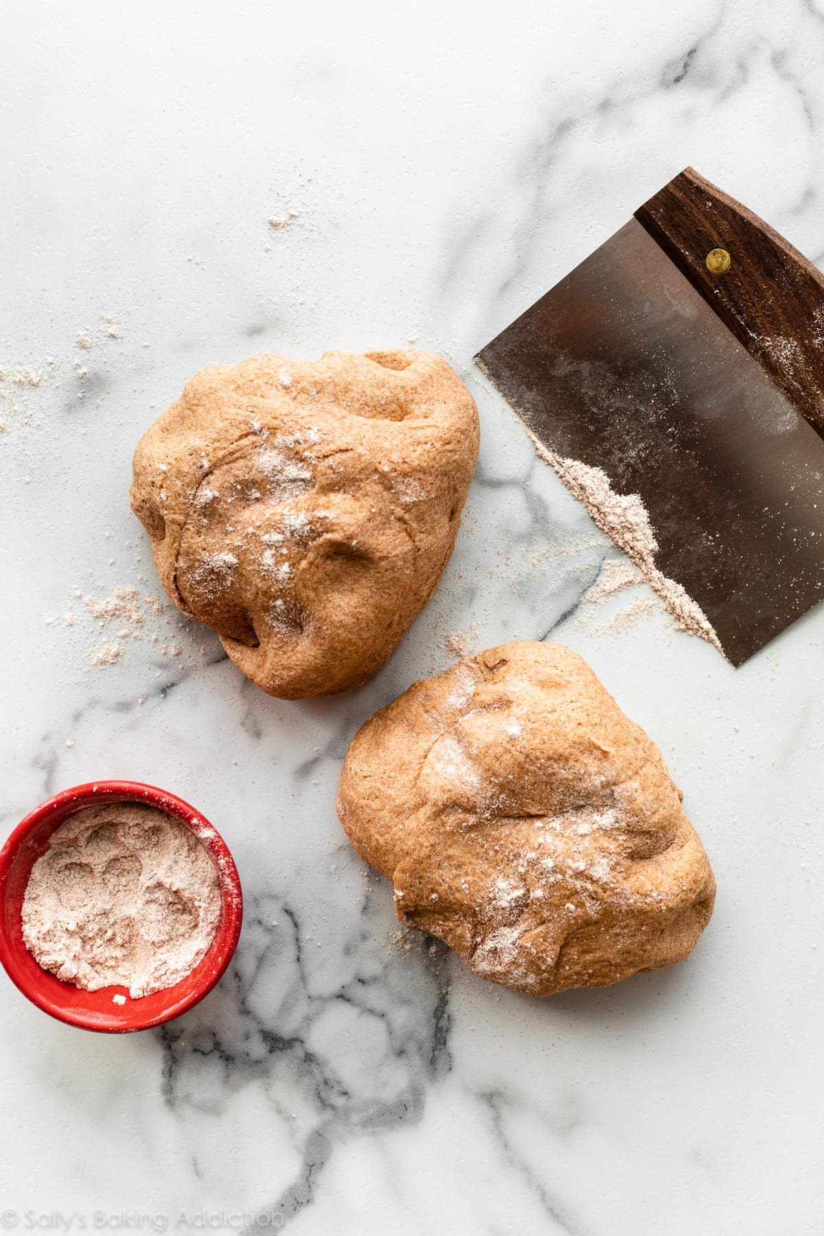 whole wheat dough cut in half on marble counter
