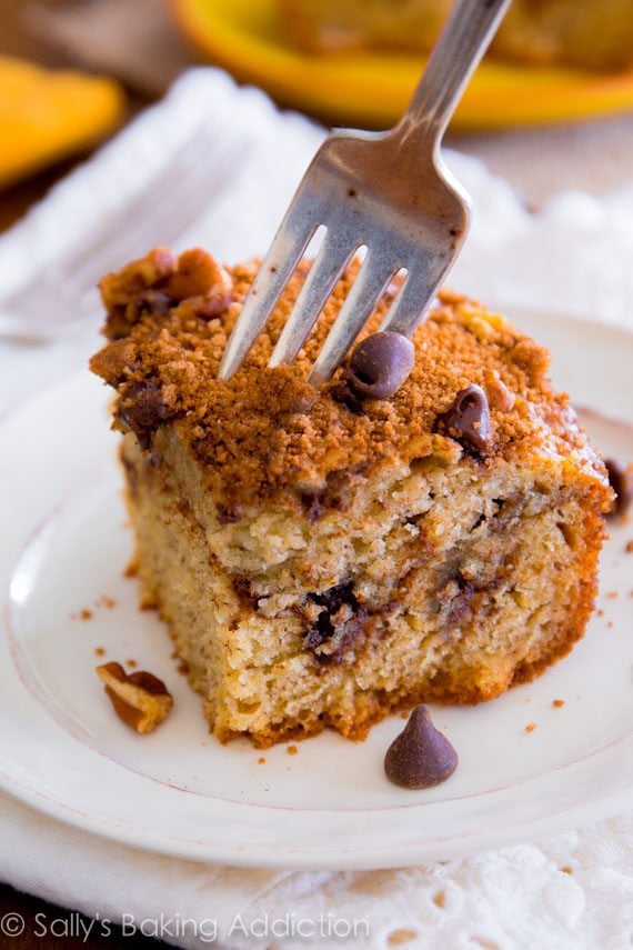 slice of banana chocolate chip crumb cake on a white plate with a fork