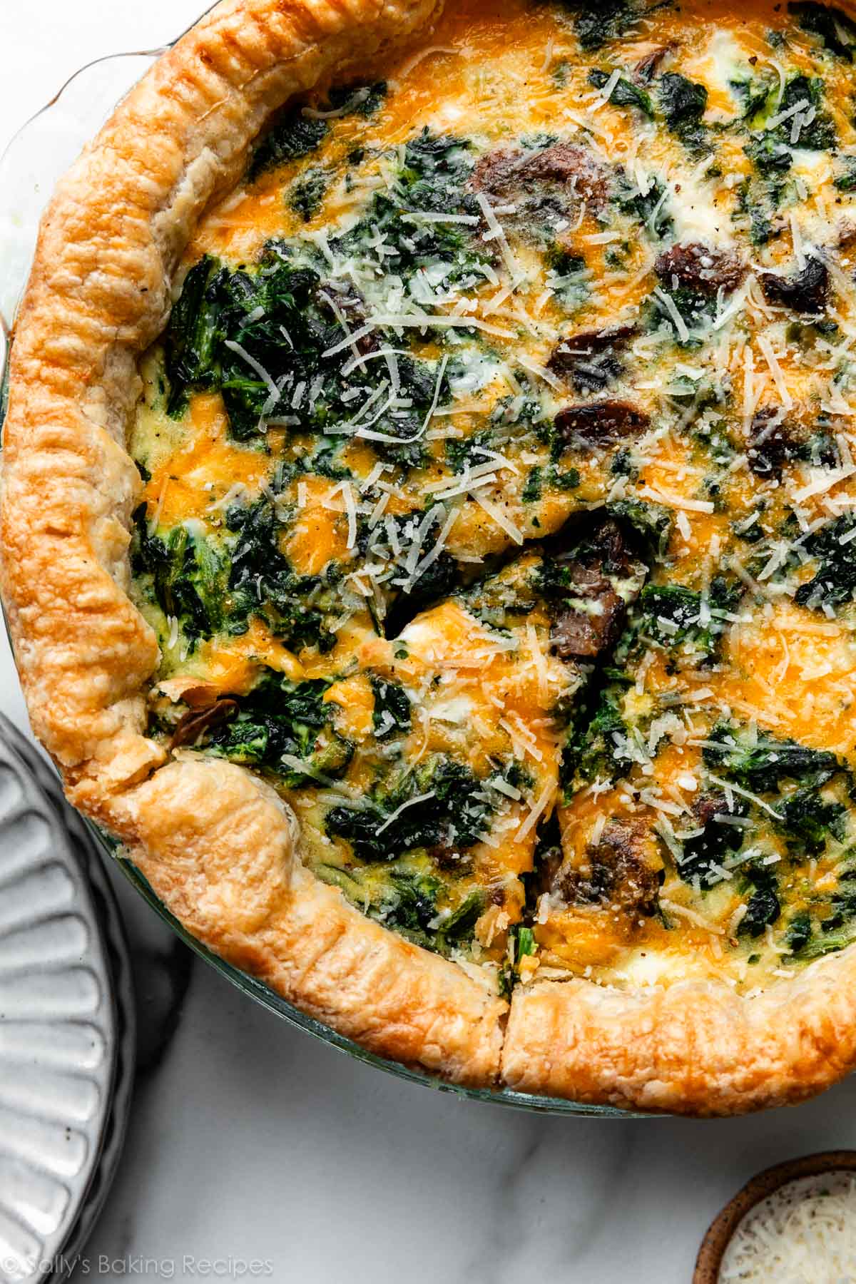 slice of spinach quiche cut out before removing from pie dish.