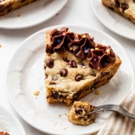 slices of chocolate chip cookie cake on white plates.