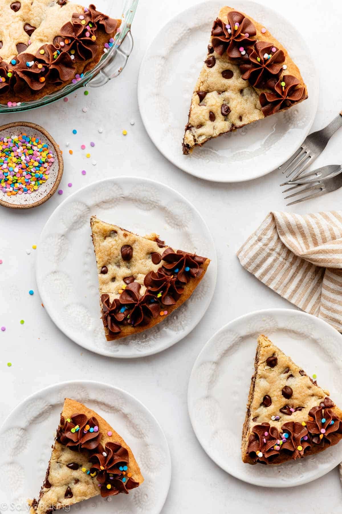 individual slices of chocolate chip cookie cake with chocolate buttercream and rainbow sprinkles.