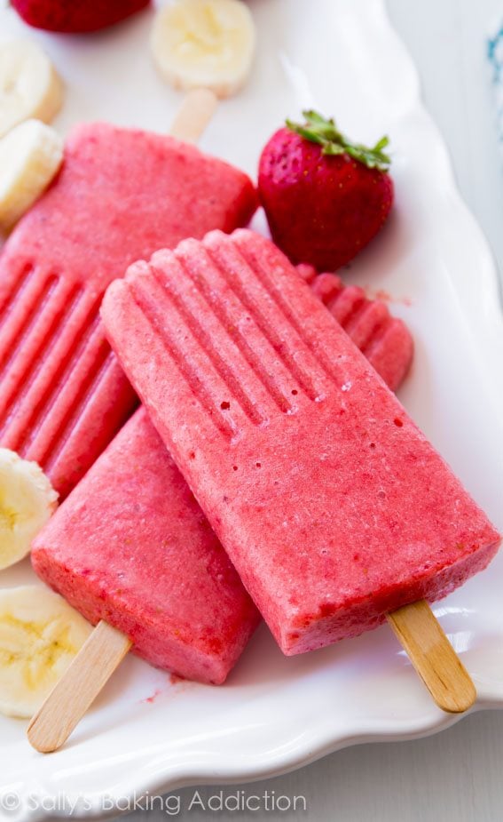 strawberry banana popsicles on a white serving tray