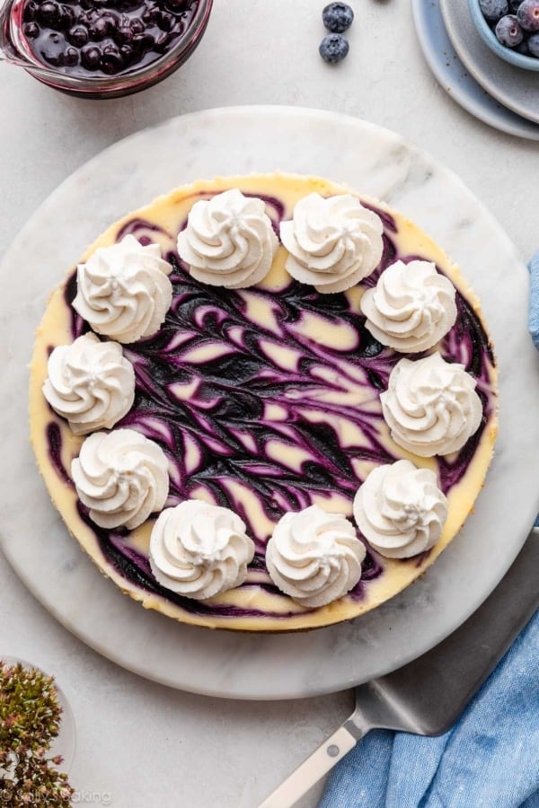 blueberry swirl cheesecake with whipped cream piped on top.