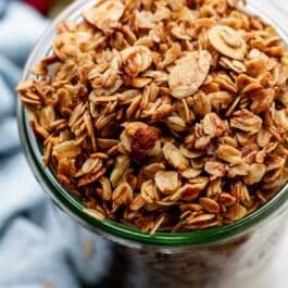 tall jar of vanilla granola with sliced almonds.