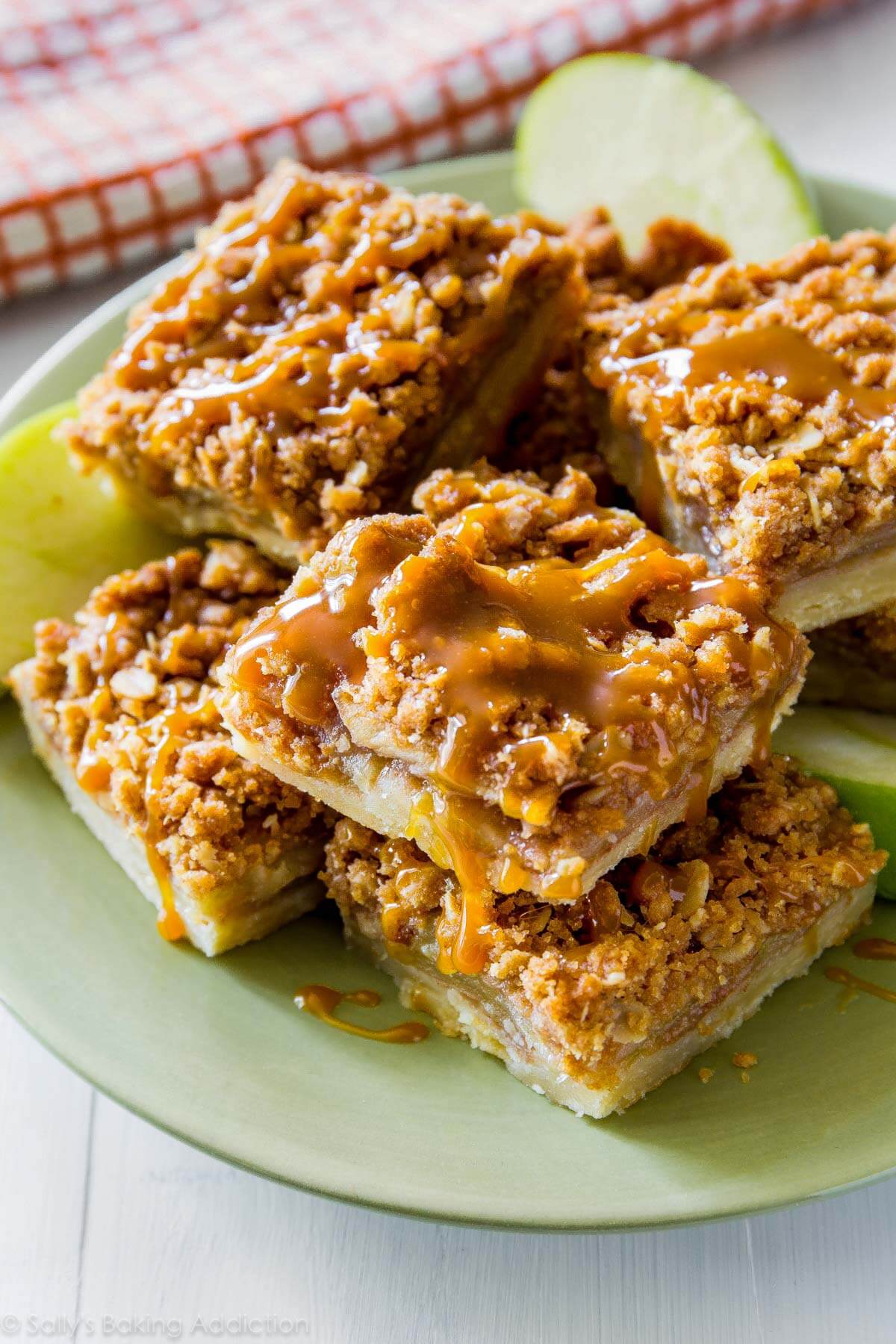 apple pie bars with salted caramel sauce topping on a green plate