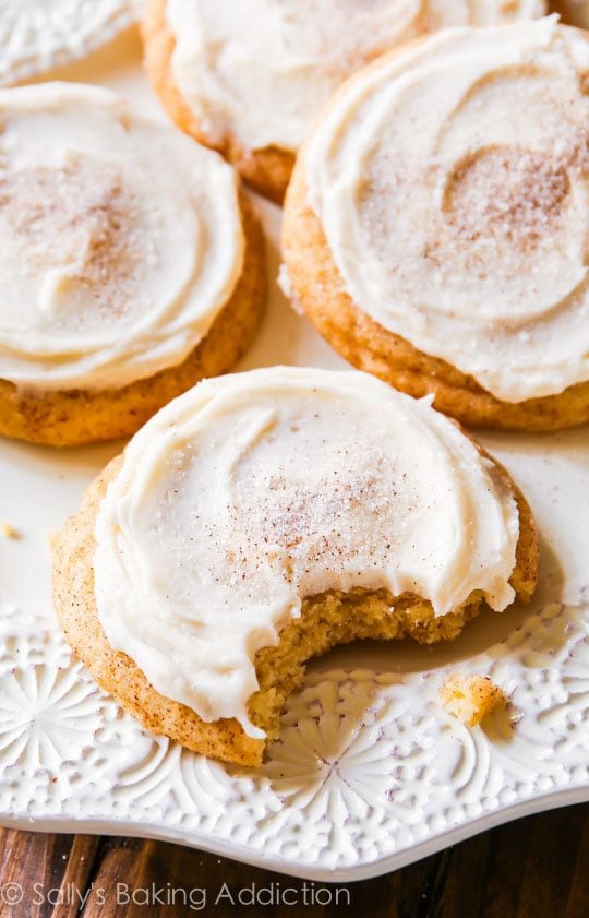 frosted chai spice snickerdoodles on a white plate with a bite taken out of one cookie