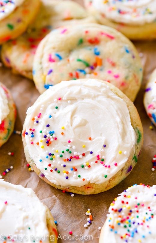sugar cookies with sprinkles topped with vanilla frosting and sprinkles
