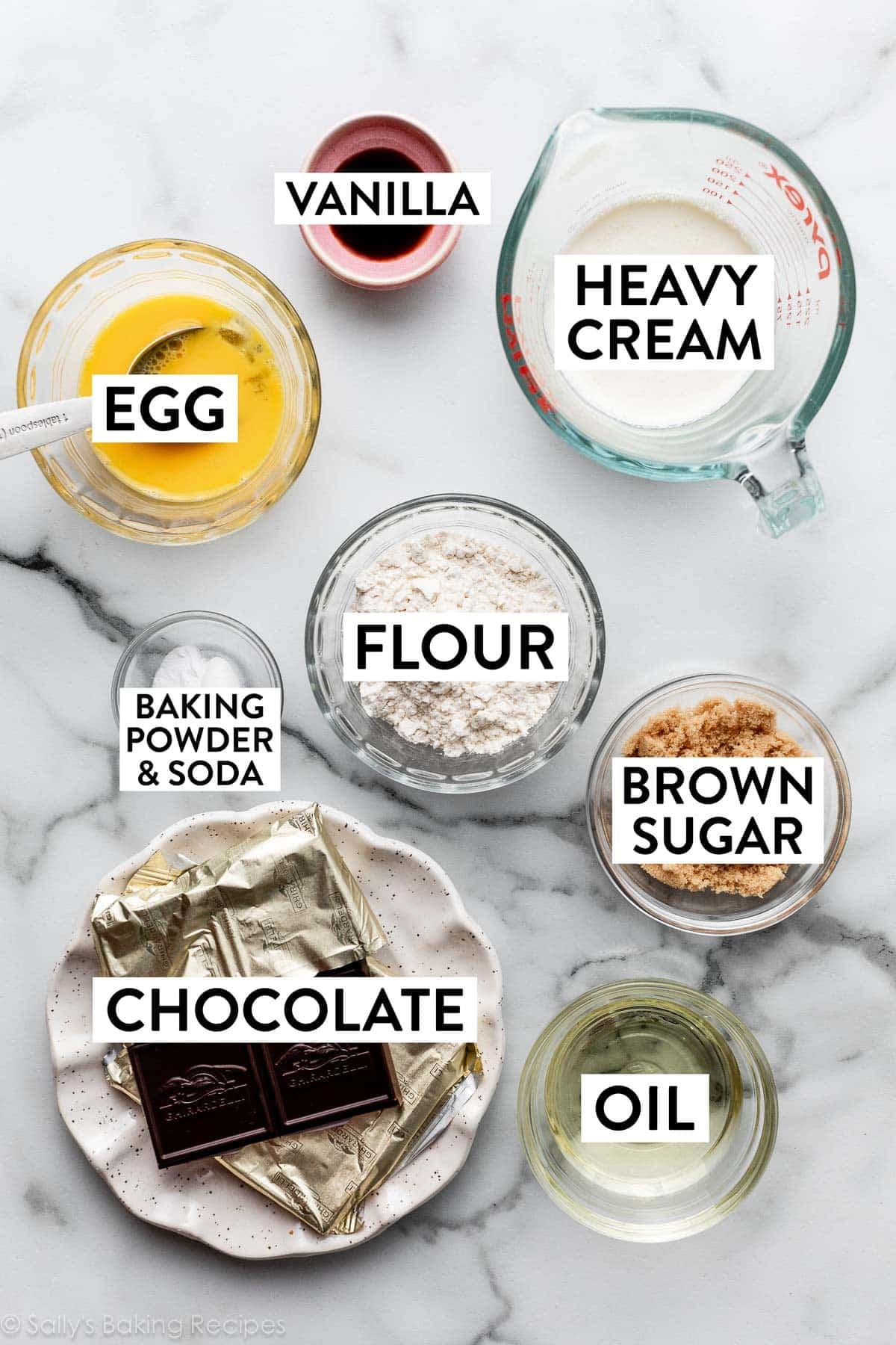 ingredients on counter including flour, heavy cream, brown sugar, oil, beaten egg, and vanilla.