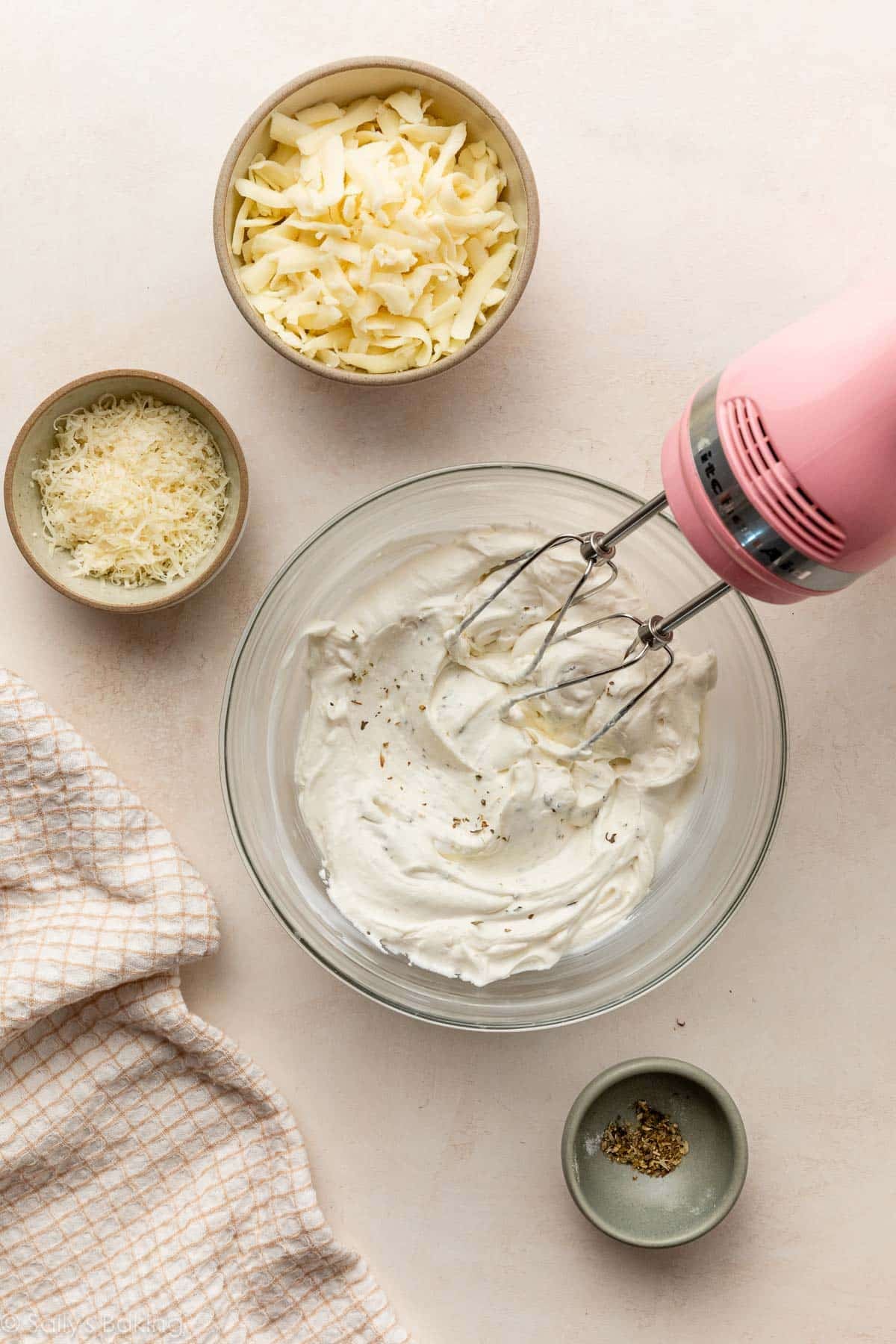 pink and mixer with bowl of sour cream and cheese cheese mixture.