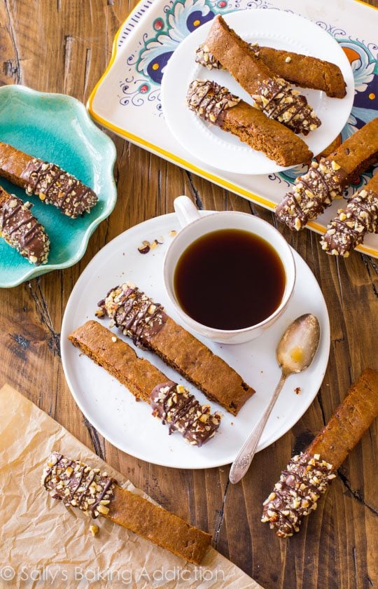 overhead image of mocha chip biscotti on white plates with coffee cups