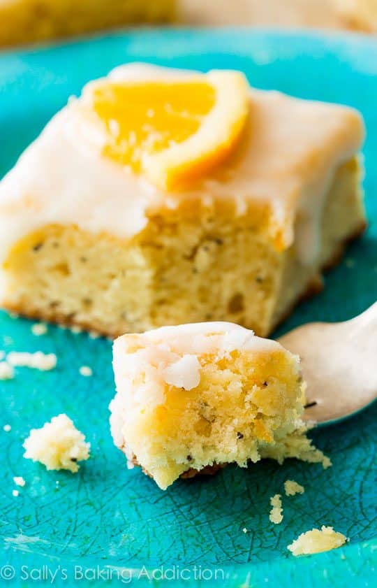 glazed orange poppy seed bar on a blue plate with a fork