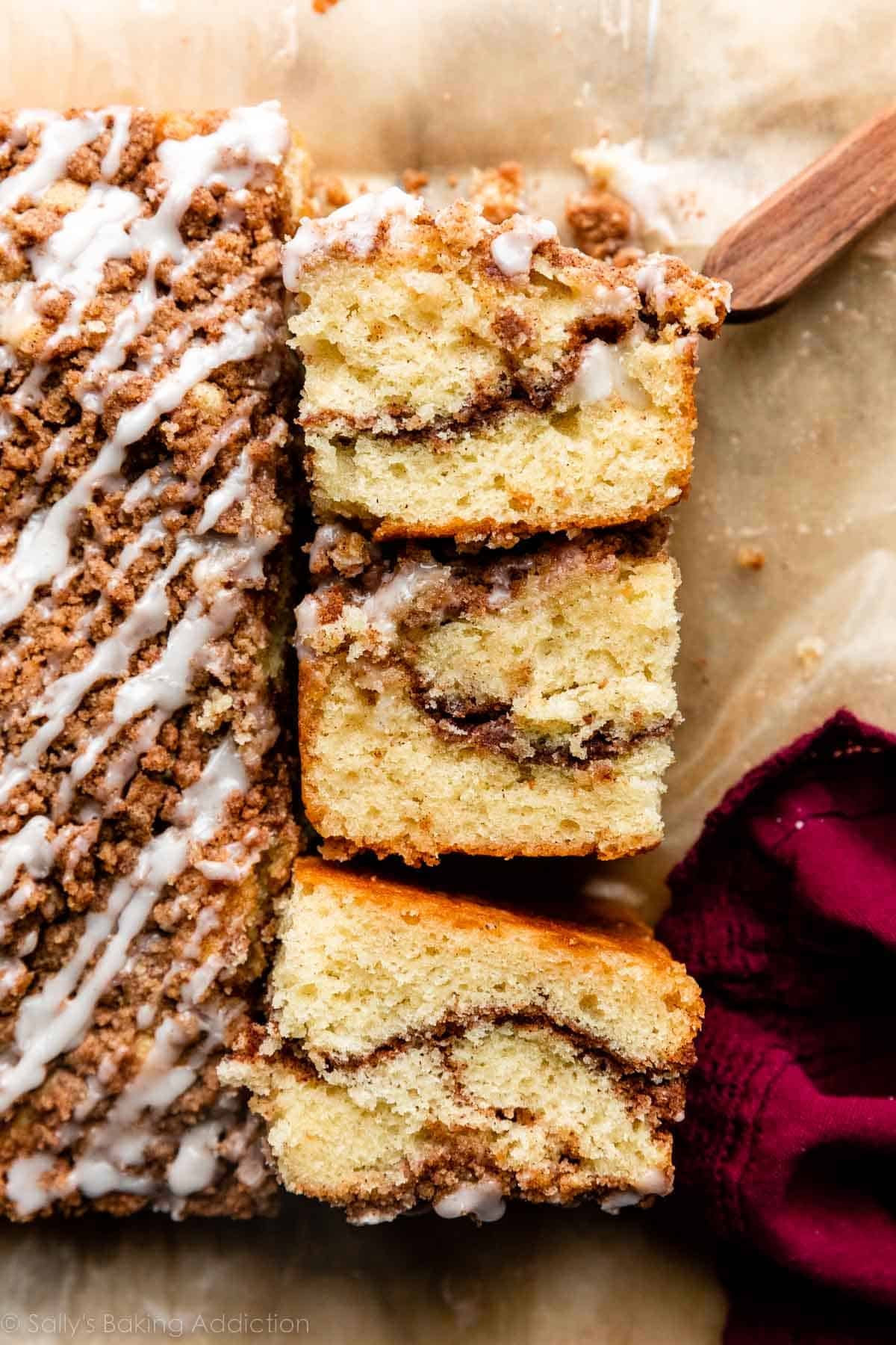 overhead photo of cinnamon crumb coffee cake cut into squares with 3 turned on their side to show cinnamon swirl center.