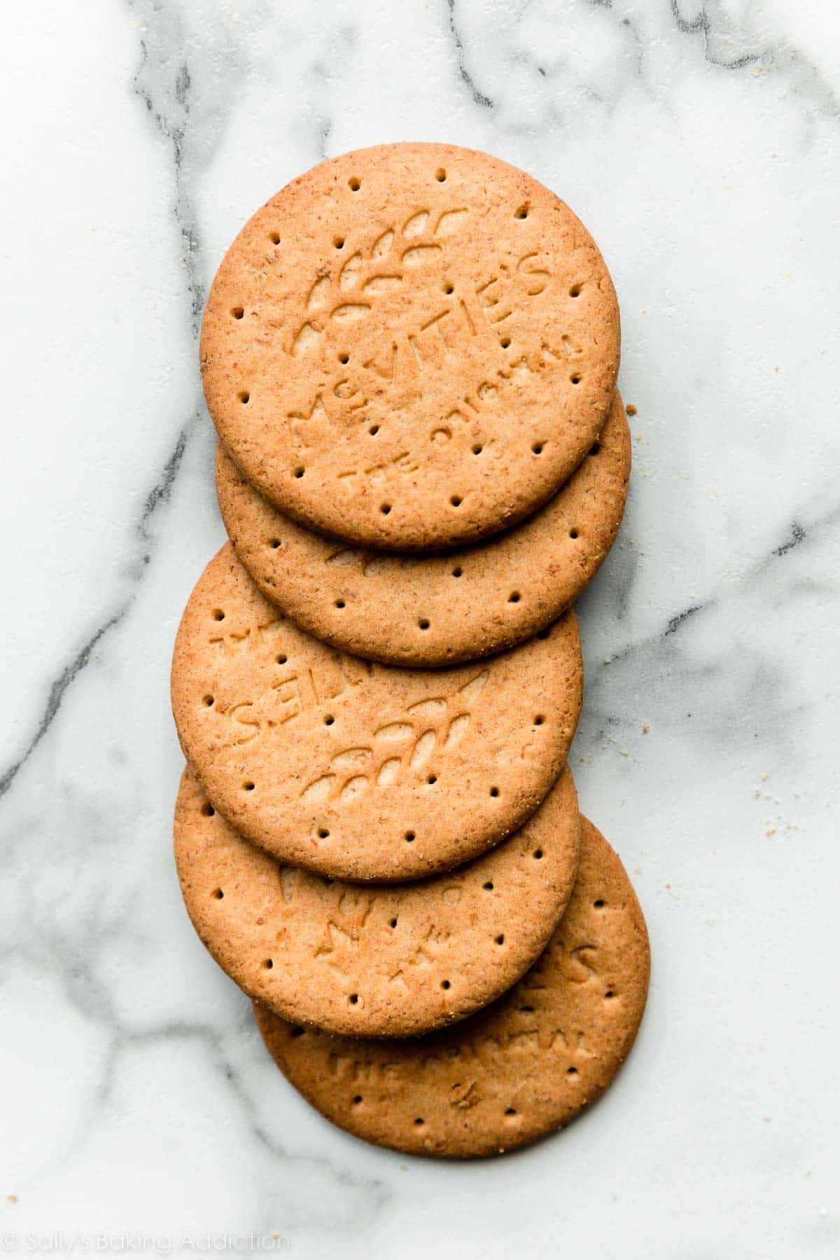 5 digestive biscuits on marble countertop.