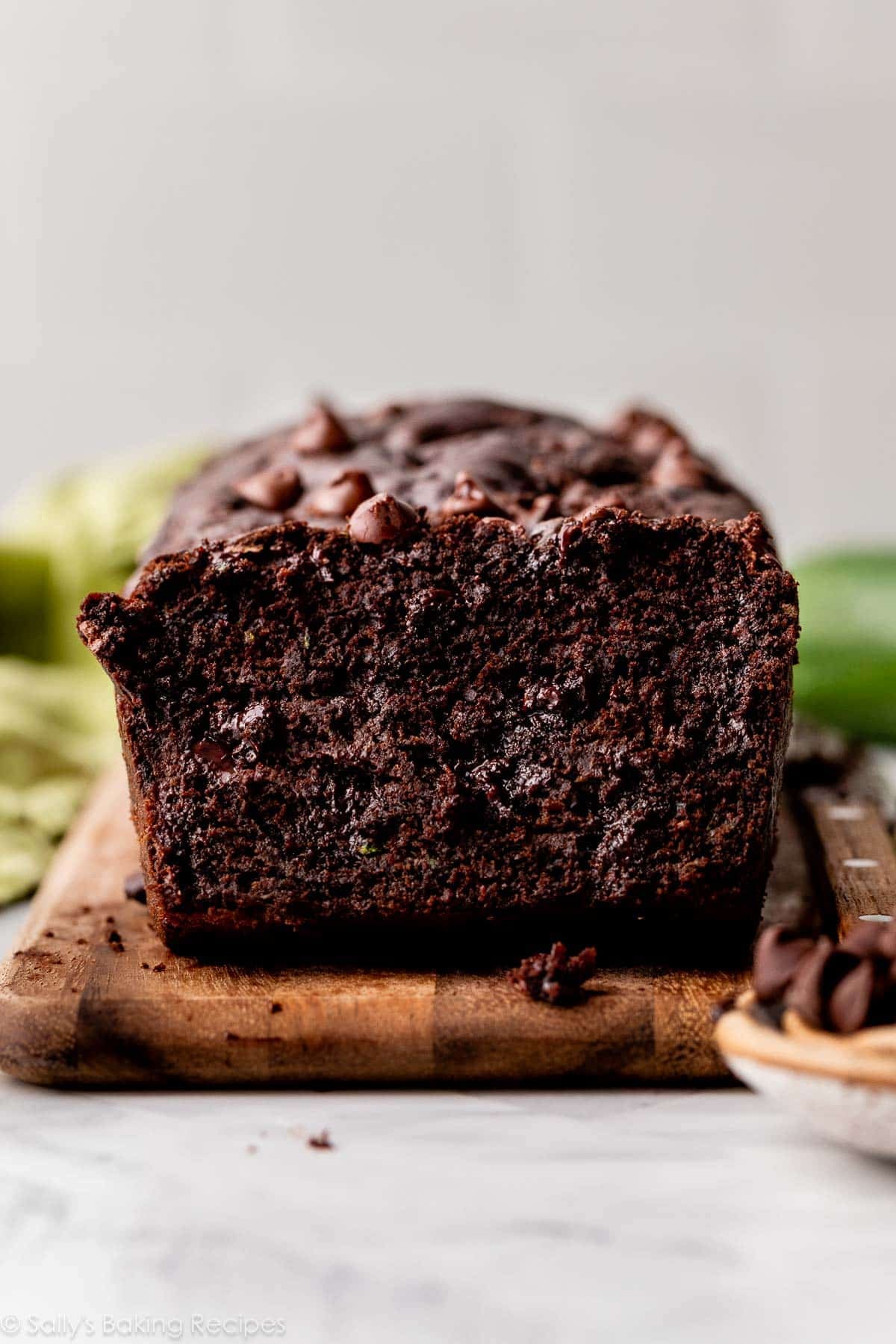 double chocolate zucchini bread with chocolate chips on wooden cutting board.