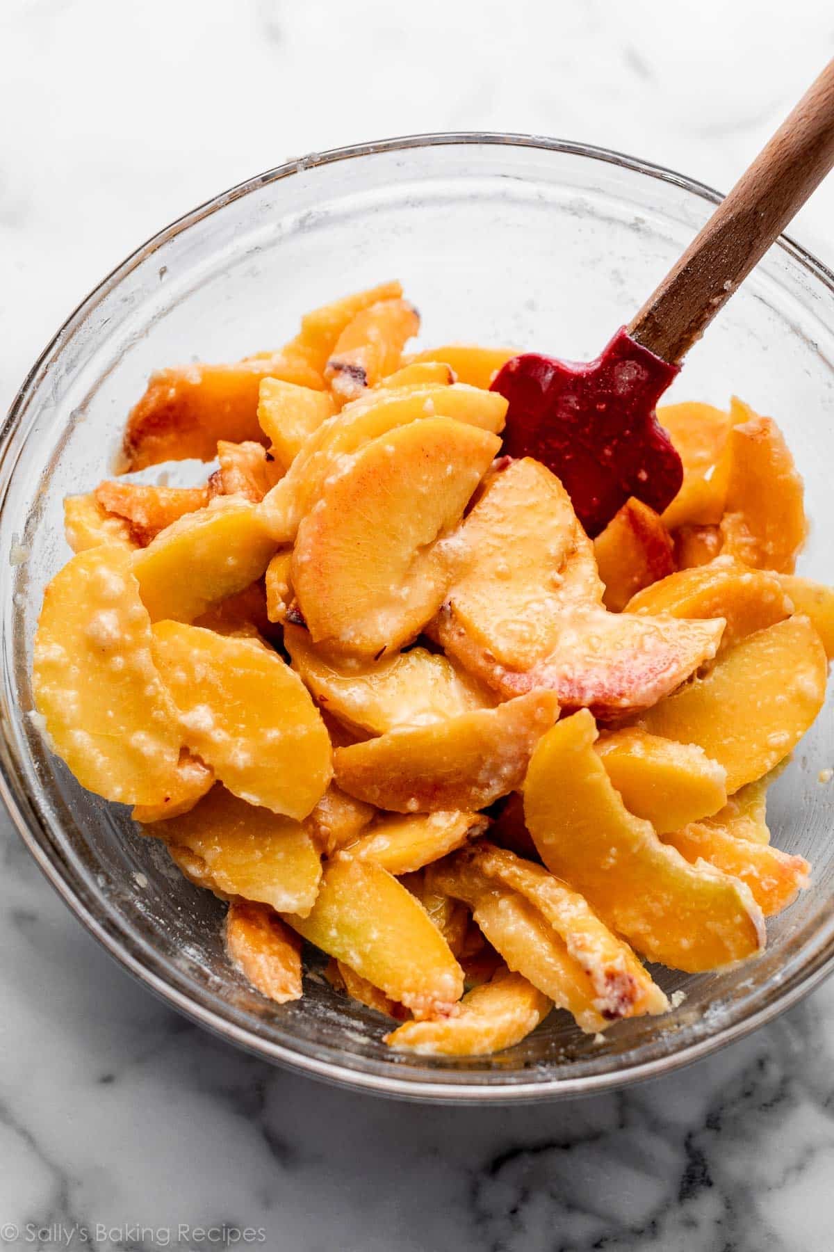 peach filling in glass bowl with red spatula.