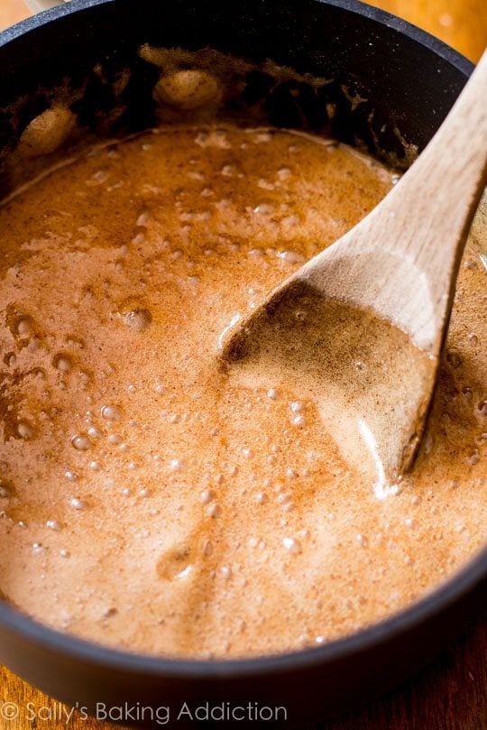 caramel mixture in a saucepan with a wood spoon
