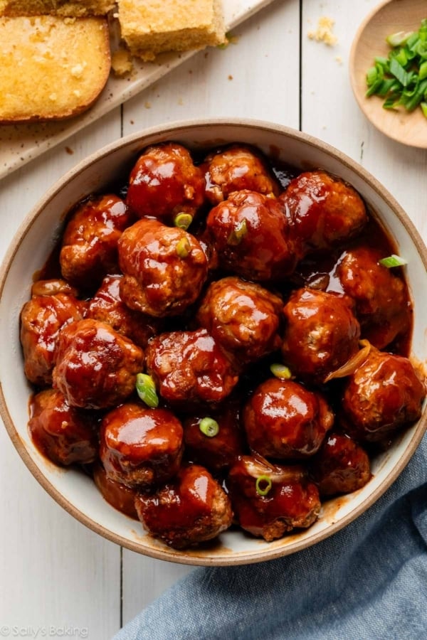 bbq meatballs in bowl with green onion garnish.