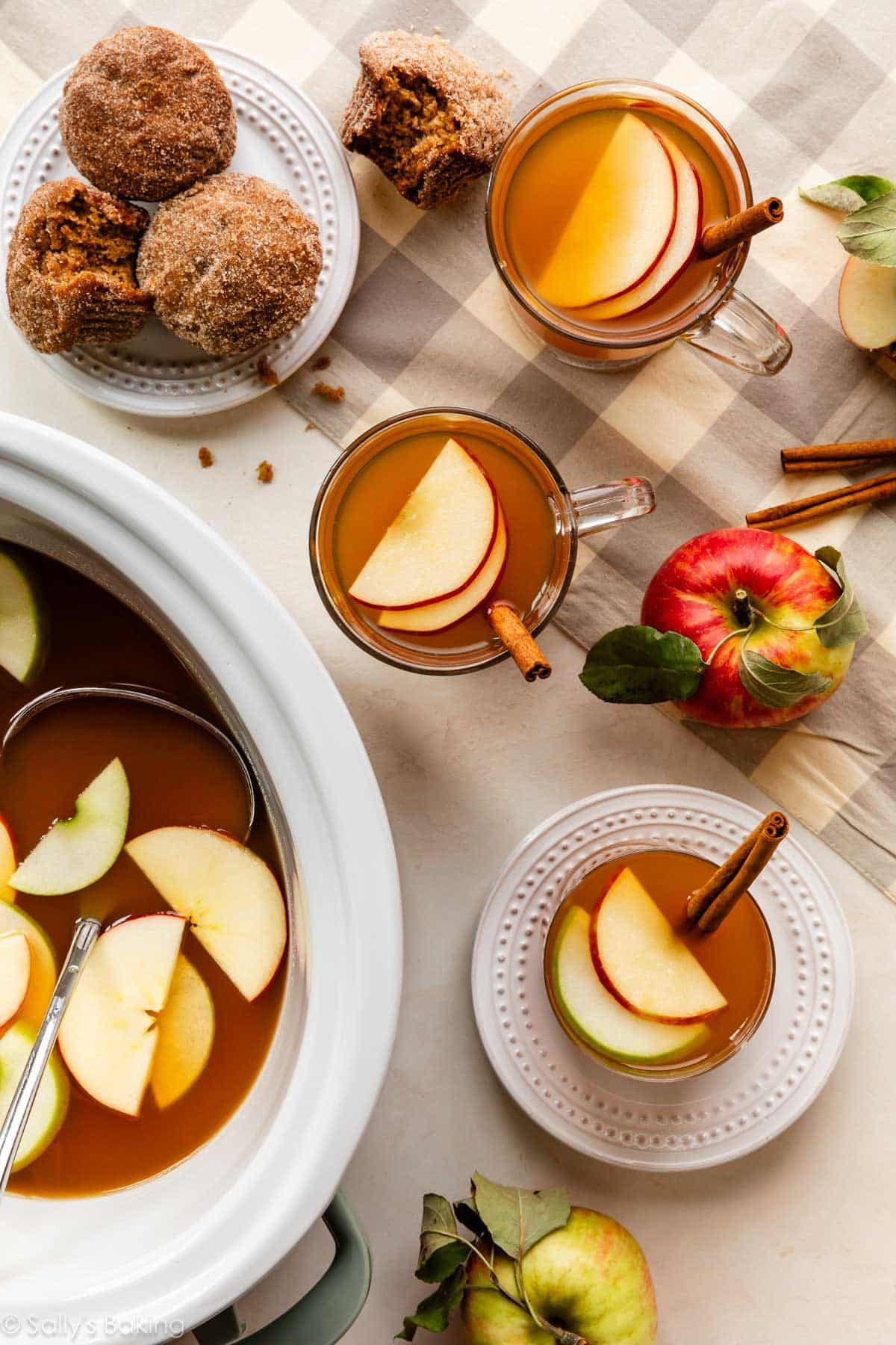 glass mugs of homemade apple cider and apple cider muffins on plate.