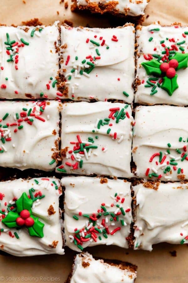 overhead shot of cream cheese frosted cake with red, green, and white sprinkles on top.