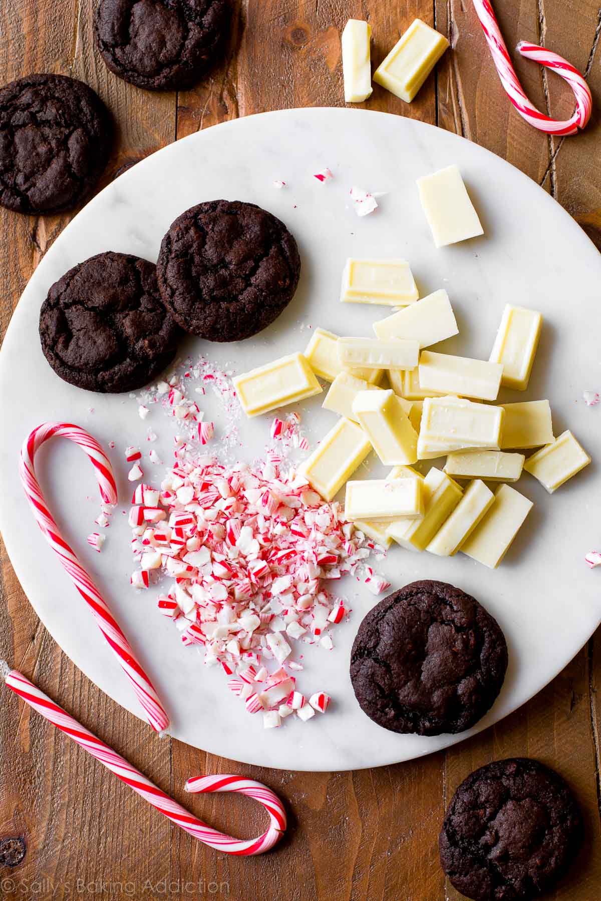 overhead image of mocha cookies on a marble serving tray with chopped white chocolate and crushed candy canes