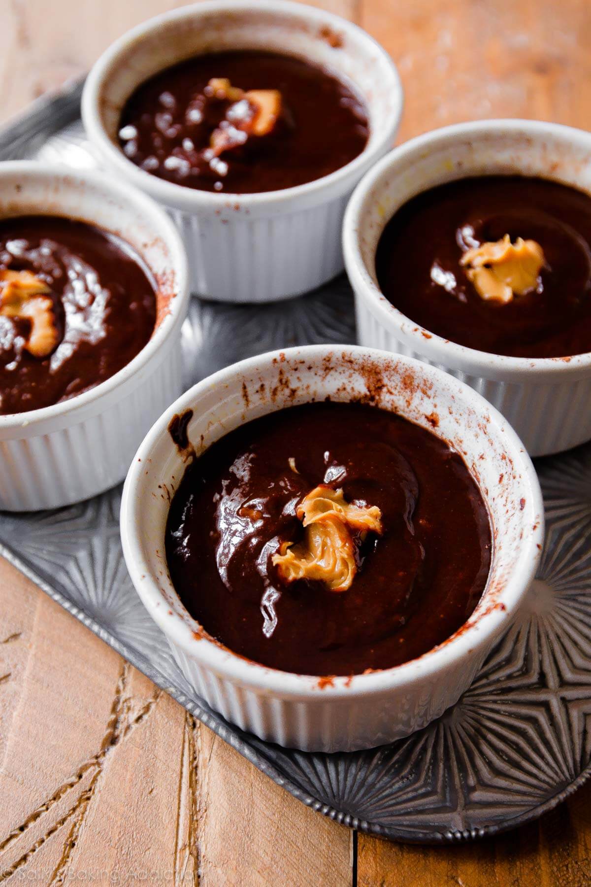white ramekins filled with chocolate lava cake batter and peanut butter in the centers before baking