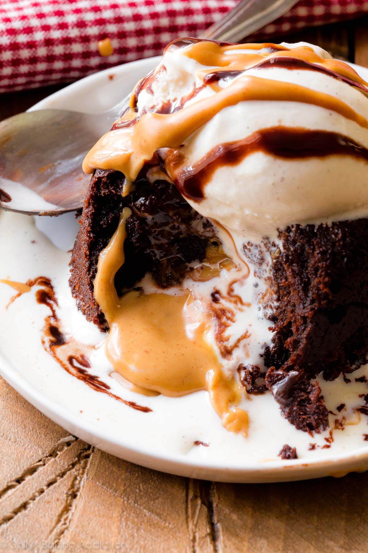 peanut butter chocolate lava cake on a white plate with a scoop of vanilla ice cream on top