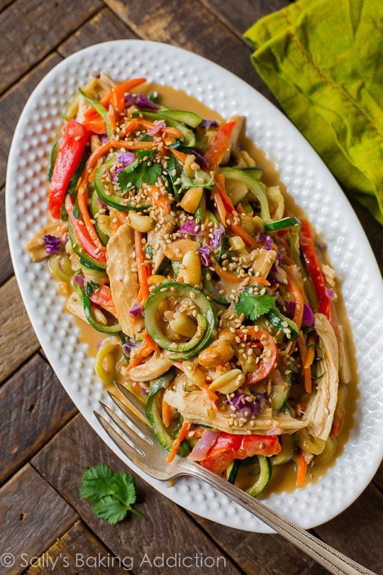 overhead image of peanut chicken zucchini noodles on a white serving tray