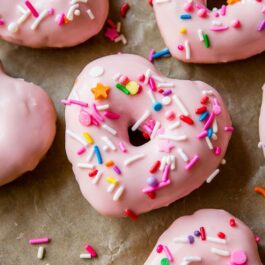 heart shaped donuts topped with pink glaze and sprinkles