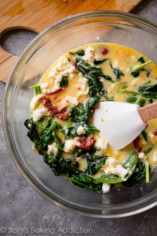 filling for goat cheese spinach sun-dried tomato quiche in a glass bowl