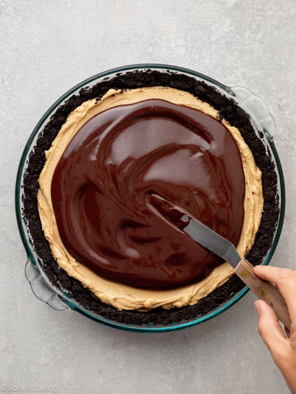 spreading chocolate ganache on top of peanut butter filling.