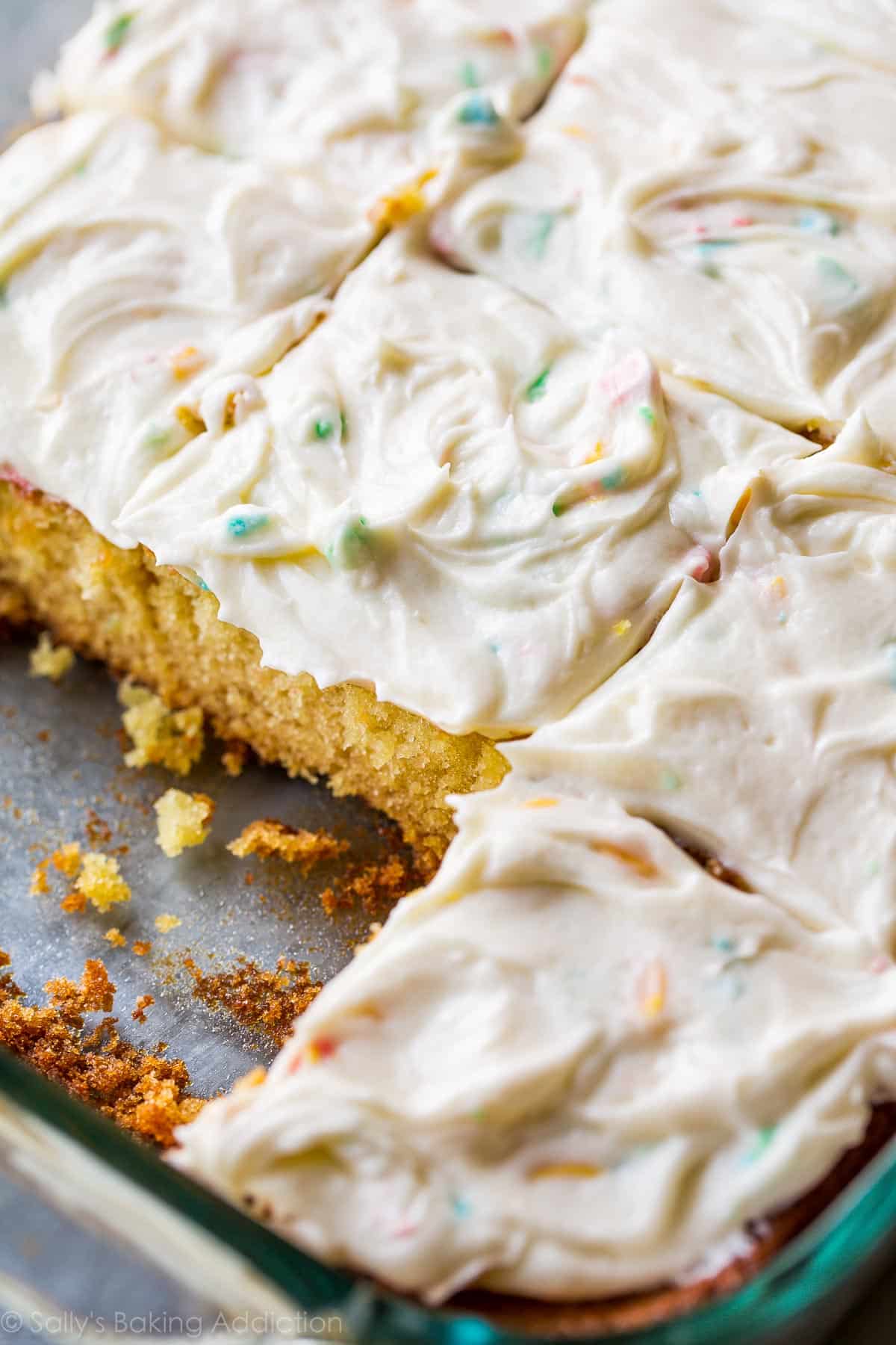 sheet cake in a glass pan with rainbow chip frosting spread on top
