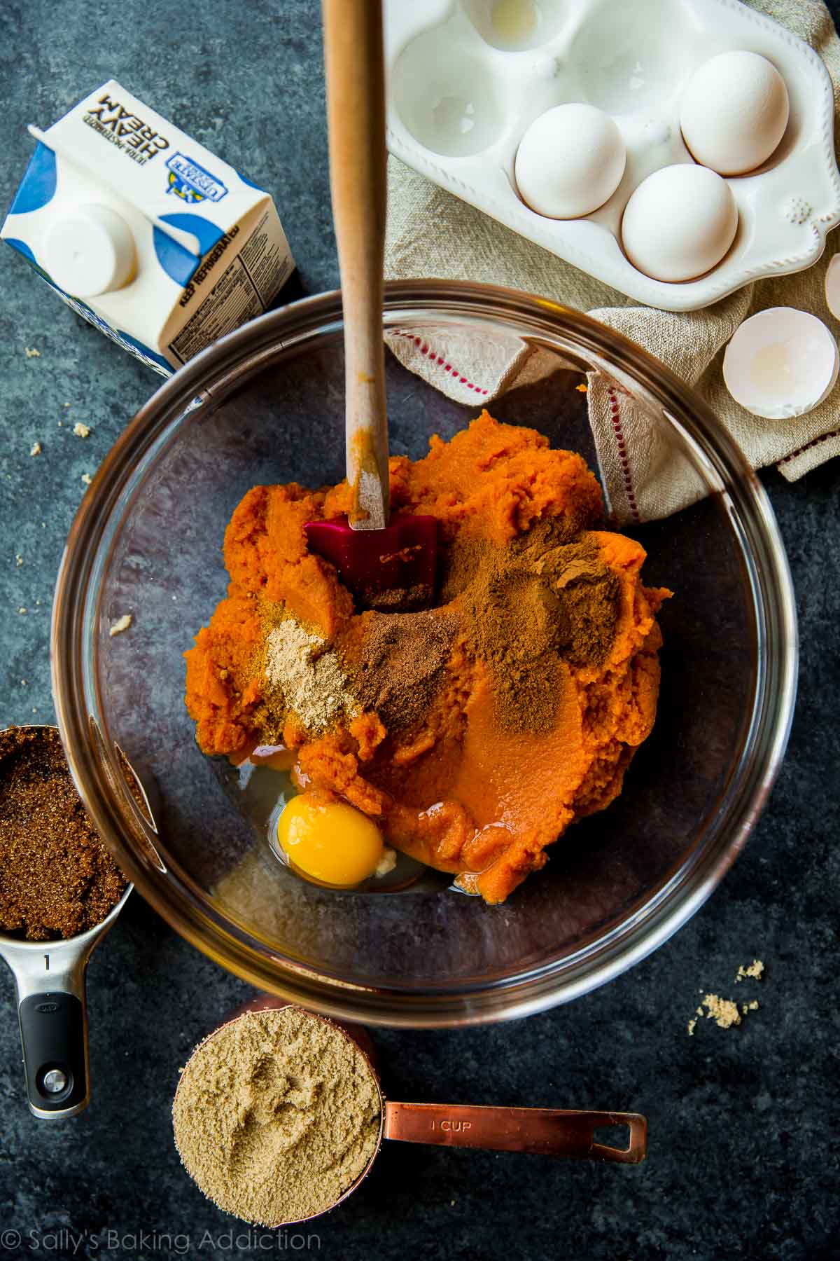 pumpkin pie filling ingredients in a glass bowl with a spatula