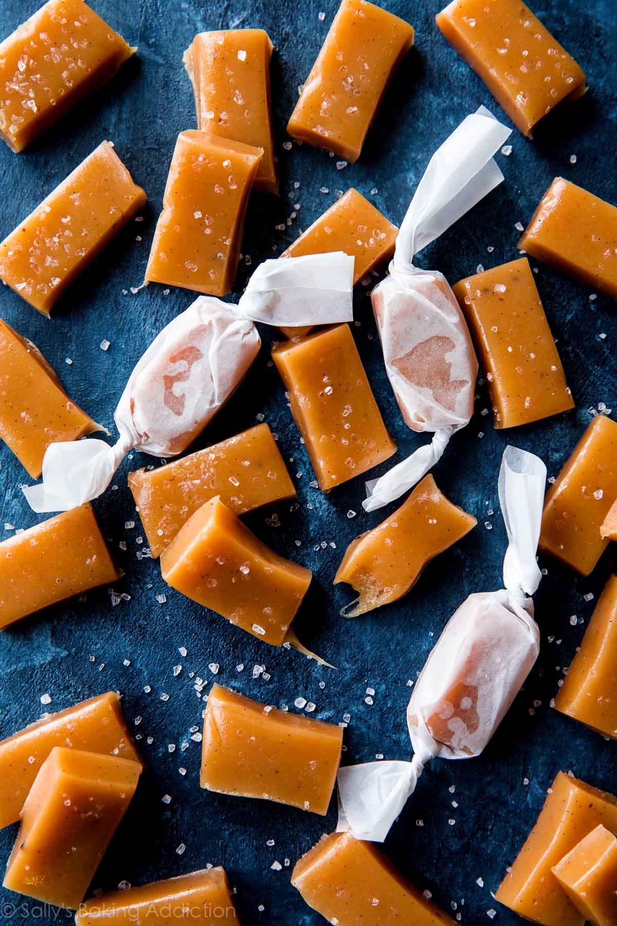 sea salt vanilla caramels cut into small rectangles with some wrapped in candy wrappers