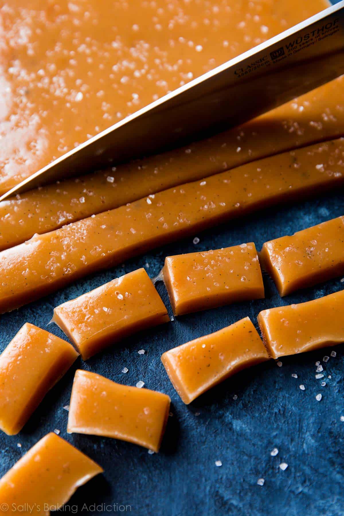 knife slicing sea salt vanilla caramel into small rectangles
