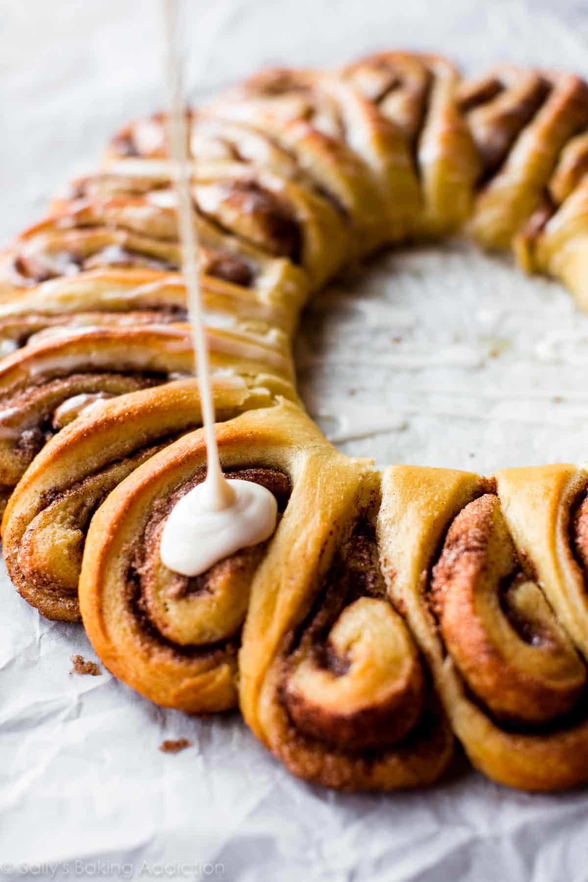 drizzling vanilla icing onto cinnamon roll wreath
